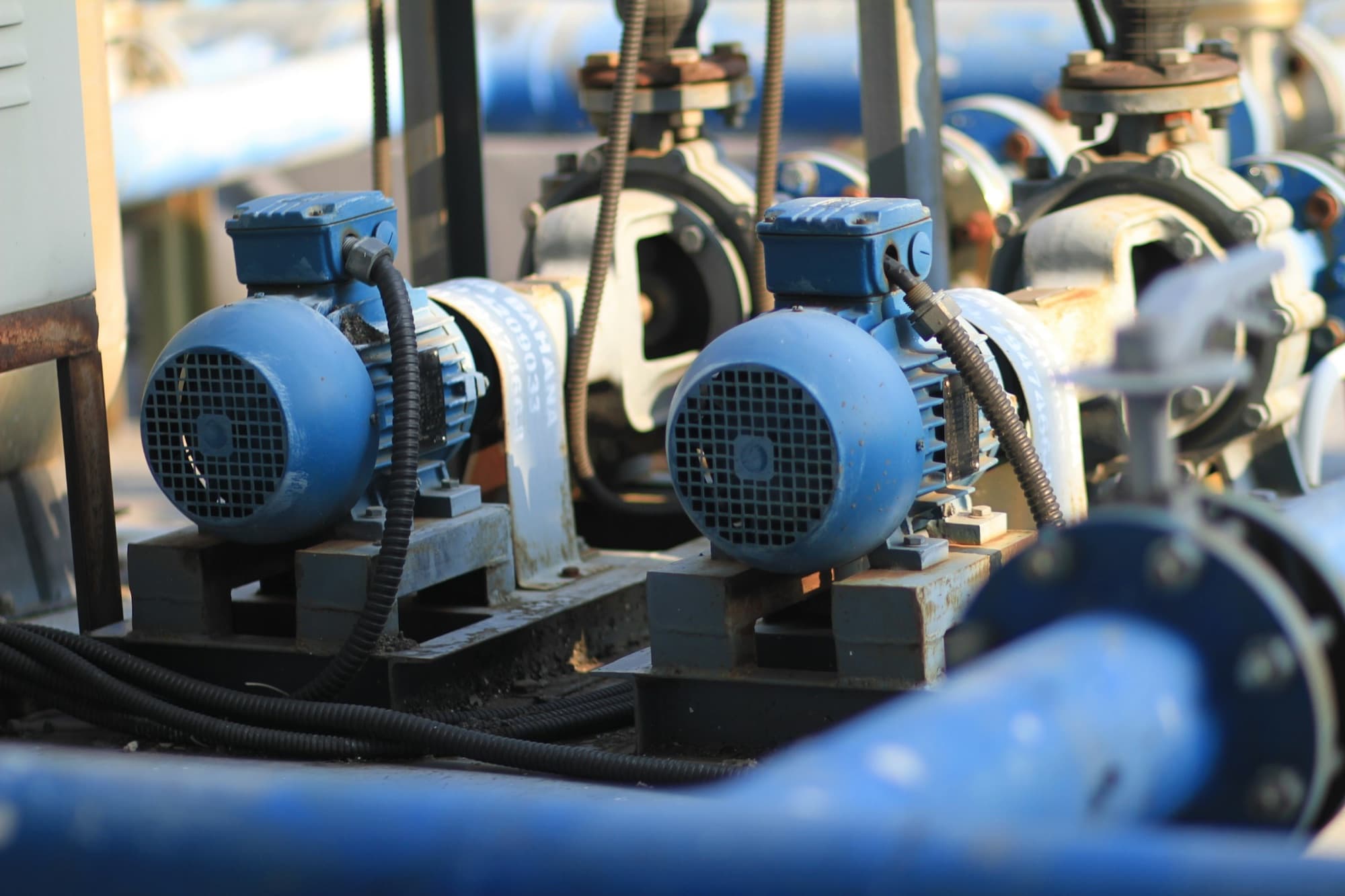 Pair of motor-driven centrifugal pumps on steel bases with flanged piping and conduit