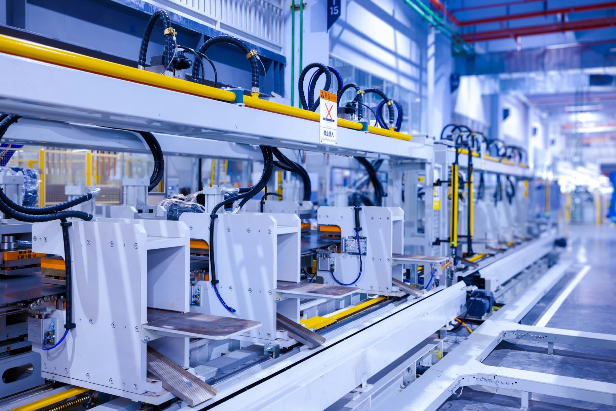 Automated sheet metal transfer line with stations holding formed steel panels in a bright appliance plant