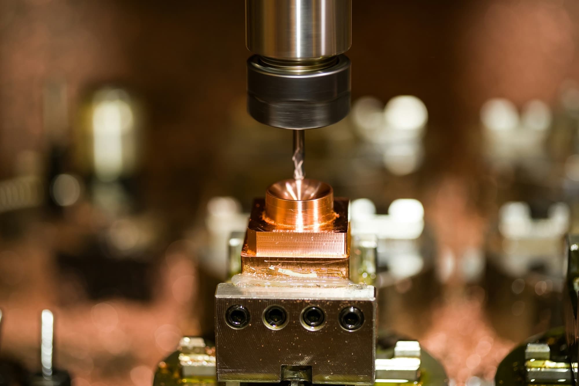 Small end mill machining a copper prototype part held in a vise on a CNC machine
