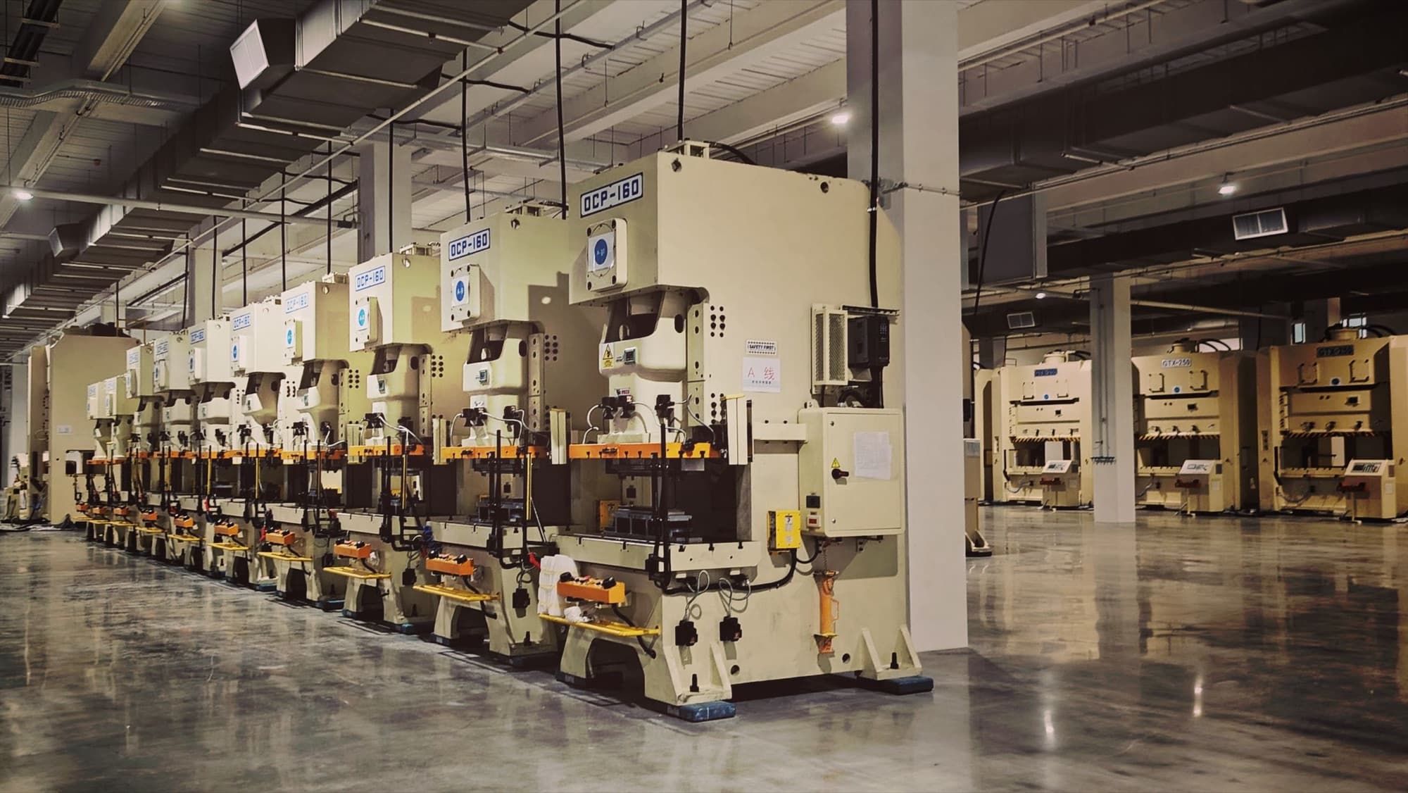 Line of C-frame mechanical stamping presses with die sets installed on a clean pressroom floor