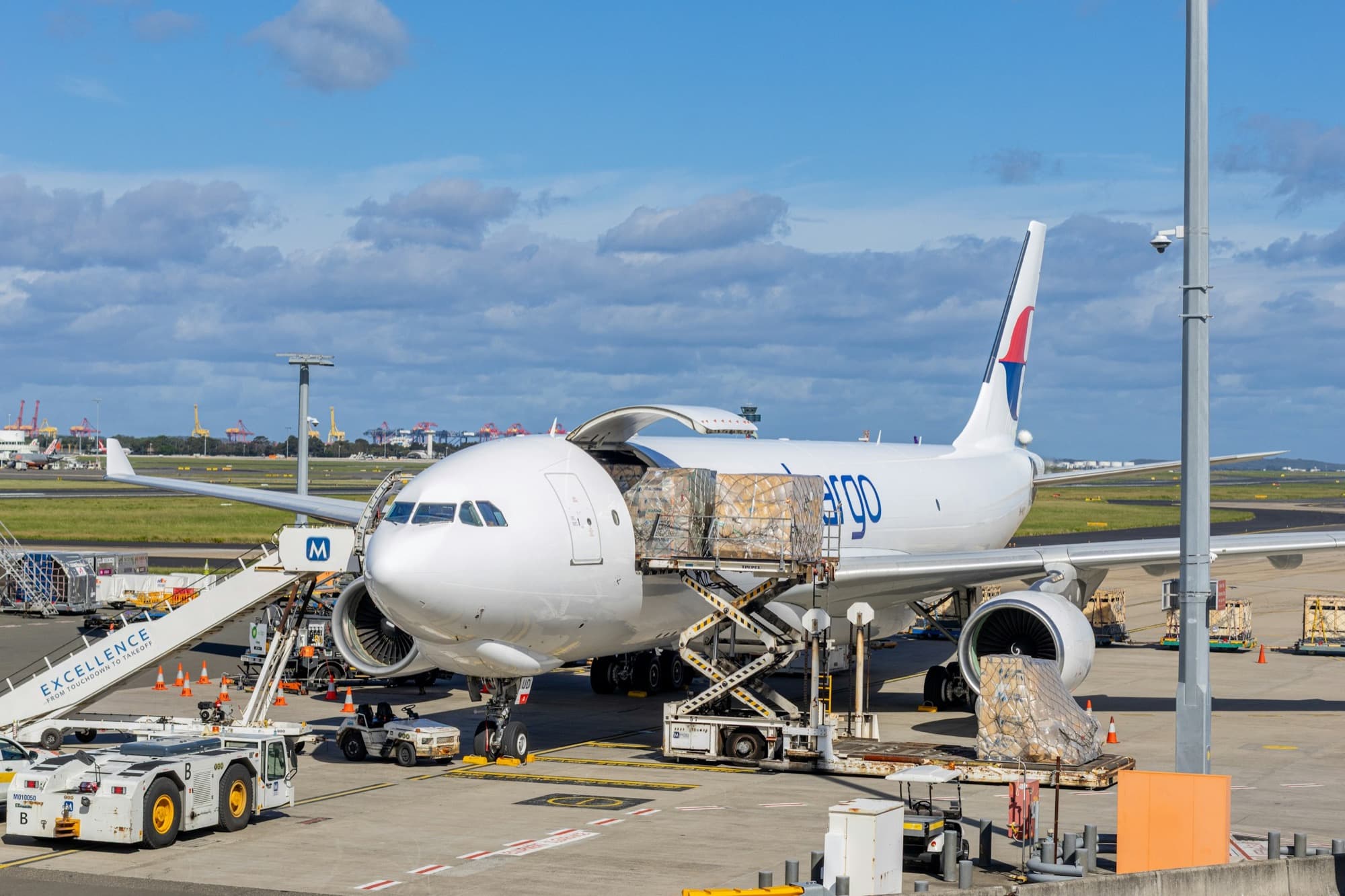 Palletized air cargo on a scissor loader at the main-deck door of a freighter aircraft